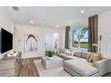 Bright living room featuring stylish decor, a modern sectional sofa, and views of the landscaped exterior at 8691 Sw 57Th Ln, Ocala, FL 34481