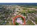 Aerial view of a neighborhood featuring mature trees and a home with a private screened-in pool at 1634 Lady Bowers Trl, Lakeland, FL 33809