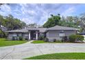 Charming one-story home with well-maintained landscaping and a concrete driveway with some tree cover at 1634 Lady Bowers Trl, Lakeland, FL 33809