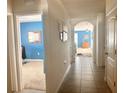 Inviting hallway with tiled floor and bright blue accent wall, giving view to multiple rooms at 2987 Neverland Dr, New Smyrna Beach, FL 32168