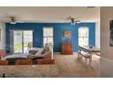Cozy living area with neutral tones, ceiling fans, and sliding glass doors to the outdoor space at 2987 Neverland Dr, New Smyrna Beach, FL 32168