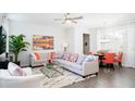 Bright open-concept living room featuring a large sectional sofa, decorative pillows, and a modern glass coffee table at 3013 Howley Aly, St Cloud, FL 34771