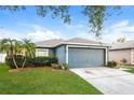 Lovely single-story home featuring manicured landscaping and a gray two-car garage at 2216 Heathwood Cir, Orlando, FL 32828