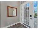 Light filled foyer showcases a mirror, wood flooring, and glass paneled front door at 1530 The Oaks Blvd, Kissimmee, FL 34746