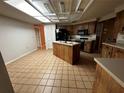Traditional kitchen with a central island, a black appliance suite, and tile flooring at 3050 Carolina Ave, Lakeland, FL 33803