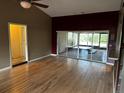 Bright living room with hardwood floors, a ceiling fan, and glass doors leading to the outdoor patio at 3050 Carolina Ave, Lakeland, FL 33803