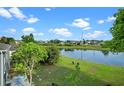 The backyard offers a serene pond view, a manicured lawn, and patio seating, enhancing the property's appeal at 1322 Aguacate Ct, Orlando, FL 32837