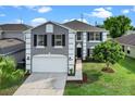 Two story home featuring a gray exterior with white trim, black shutters, a manicured lawn, and a two-car garage at 1322 Aguacate Ct, Orlando, FL 32837