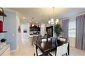 Open-concept dining area with stylish chandelier and seamless flow into a modern kitchen at 1888 Bright Sky Dr, Kissimmee, FL 34744