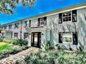 Exterior view of building, landscaping, brick facade, and updated windows with black shutters at 296 Lewfield Cir, Winter Park, FL 32792