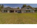 Lovely backyard view of the home with expansive green lawn, and covered patio for outdoor living at 4004 Se 47Th Pl, Ocala, FL 34480