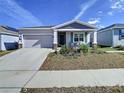 Single-Gathering home boasts a well-kept lawn and attached garage with charming front porch at 590 Tanaro Ln, Haines City, FL 33844