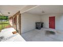Attached carport featuring brick accents, a red door, and ample storage space at 1123 Enchanted Dr, Lakeland, FL 33801