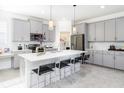 Modern kitchen with gray cabinets, stainless appliances, a pantry and a large island with bar seating at 3001 Namaste Dr, Clermont, FL 34714