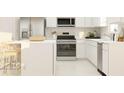 Modern kitchen featuring white cabinets, stainless steel appliances, and a convenient breakfast bar at 442 Puma Loop, Groveland, FL 34736