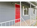 Close-up showcasing a bright red front door, white railings, and neutral-tone siding and trim at 1727 Bonita Ave, Orlando, FL 32805