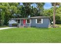 The exterior view of the house features mature trees, a carport and a cozy porch at 1727 Bonita Ave, Orlando, FL 32805