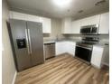 Modern kitchen featuring stainless steel appliances, granite countertops, and sleek white cabinets at 1727 Bonita Ave, Orlando, FL 32805
