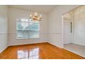 Sunlit dining room with hardwood floors, a modern chandelier, and a large window at 2214 Deerbrook Dr, Lakeland, FL 33811