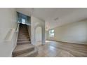 Inviting entryway with tile flooring, staircase, and arched doorway to the living area at 3002 Sunscape Ter, Groveland, FL 34736