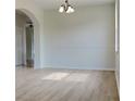 Bright living room with hardwood floors, chandelier, and large windows at 3002 Sunscape Ter, Groveland, FL 34736
