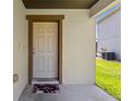 Close-up of a welcoming front door with a decorative rug on the front porch at 358 Canna Dr, Davenport, FL 33897