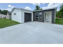 Modern home featuring a gray and white exterior, sleek windows, and a spacious driveway at 481 S East Ave, Bartow, FL 33830