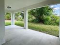 Covered patio with concrete flooring, offering a view of the backyard greenery at 481 S East Ave, Bartow, FL 33830