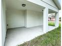 Covered patio with concrete flooring and white columns; perfect for outdoor relaxation at 481 S East Ave, Bartow, FL 33830