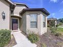 Close up front door with manicured landscape around a well maintained modern home at 8830 Fox Dr, Polk City, FL 33868