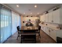 Open dining area with a view of the kitchen, lots of cabinetry, and a large sliding glass door at 1123 Sugarwood St, Davenport, FL 33837
