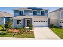 Inviting two-story home with a manicured lawn, stone accents, and attached two-car garage at 1123 Sugarwood St, Davenport, FL 33837