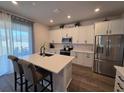 Bright kitchen featuring white cabinets, stainless steel appliances, and a large island with seating at 1123 Sugarwood St, Davenport, FL 33837