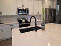 Modern kitchen with white cabinets, stainless steel appliances, a large island with a sink, and stylish decor at 1123 Sugarwood St, Davenport, FL 33837