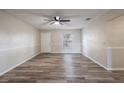 Spacious living room with wood flooring, neutral paint, ceiling fan, and a window letting in lots of natural light at 5926 N Fork Ct, Lakeland, FL 33809