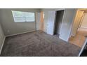 Cozy bedroom with neutral walls, plush carpeting, a window for natural light, and a closet at 2818 Dellwood Dr, Orlando, FL 32806