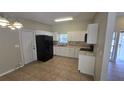 Bright kitchen boasts white cabinets, black appliances, tiled flooring, and ample counter space at 2818 Dellwood Dr, Orlando, FL 32806
