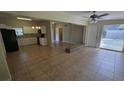 Spacious living room featuring tile floors, white trim and neutral paint with an adjacent open concept kitchen at 2818 Dellwood Dr, Orlando, FL 32806