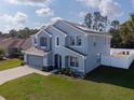 Blue two-story home boasts an expansive lawn and solar panels on its roof at 3125 Kearns Rd, Mulberry, FL 33860