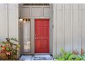 Inviting front entrance with a red door, sidelight window, and vibrant plants at 4836 Pebble Beach Dr, Orlando, FL 32811