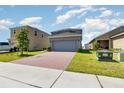Inviting two-story home with a brick driveway and a spacious two-car garage at 6889 Wilson Hammock Ave, Groveland, FL 34736