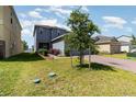 Beautifully landscaped front yard with a brick driveway leading to a two-story home at 6889 Wilson Hammock Ave, Groveland, FL 34736