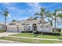 Charming single-story home featuring a three-car garage, arched entryway, and manicured landscaping at 13708 Old Dock Rd, Orlando, FL 32828