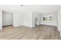 Bright, freshly painted room showcasing the wood-look flooring and access to the kitchen at 2791 Citron Dr, Longwood, FL 32779
