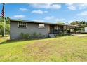 Quaint one story gray brick home, offering a covered front porch, carport, and a neatly manicured front lawn at 4145 Willow Oak Rd, Mulberry, FL 33860