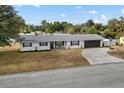 Exterior shot of a charming home with a well-manicured lawn and driveway under a bright blue sky at 455 W Plumosa St, Bartow, FL 33830