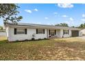 Charming brick home with fresh landscaping, dark shutters, and a inviting front porch at 455 W Plumosa St, Bartow, FL 33830