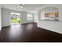 Bright living room with hardwood floors, ceiling fan, and sliding glass doors to the outside at 6354 Sedgeford Dr, Lakeland, FL 33811