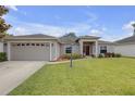 Charming single-story home features a well-manicured lawn and a welcoming front entrance with a 2 car garage at 6523 Evergreen Park Dr, Lakeland, FL 33813