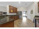Well-lit kitchen with granite countertops, stainless steel refrigerator, and tiled floors at 6523 Evergreen Park Dr, Lakeland, FL 33813
